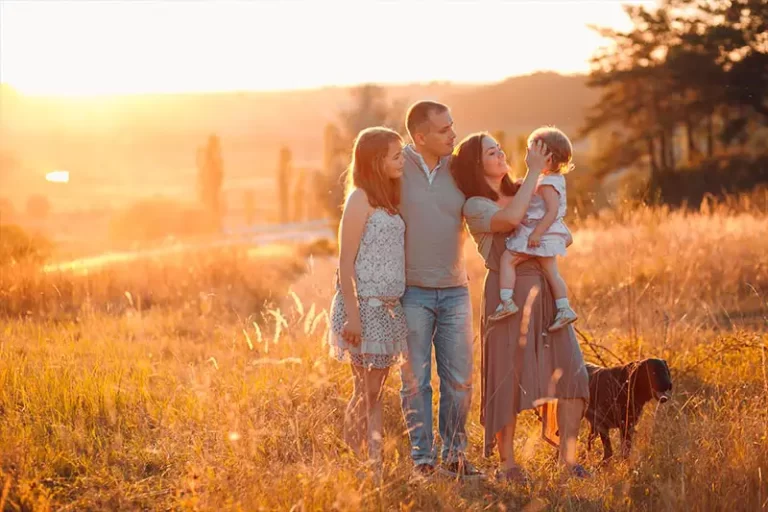 padres e hijos felices caminando por el campo